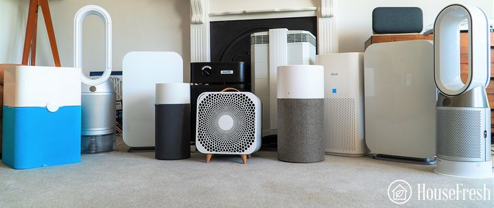 A photo of several air purifiers placed next to each other in a home setting