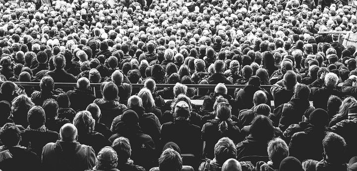 A black and white photo of a faceless crowd
